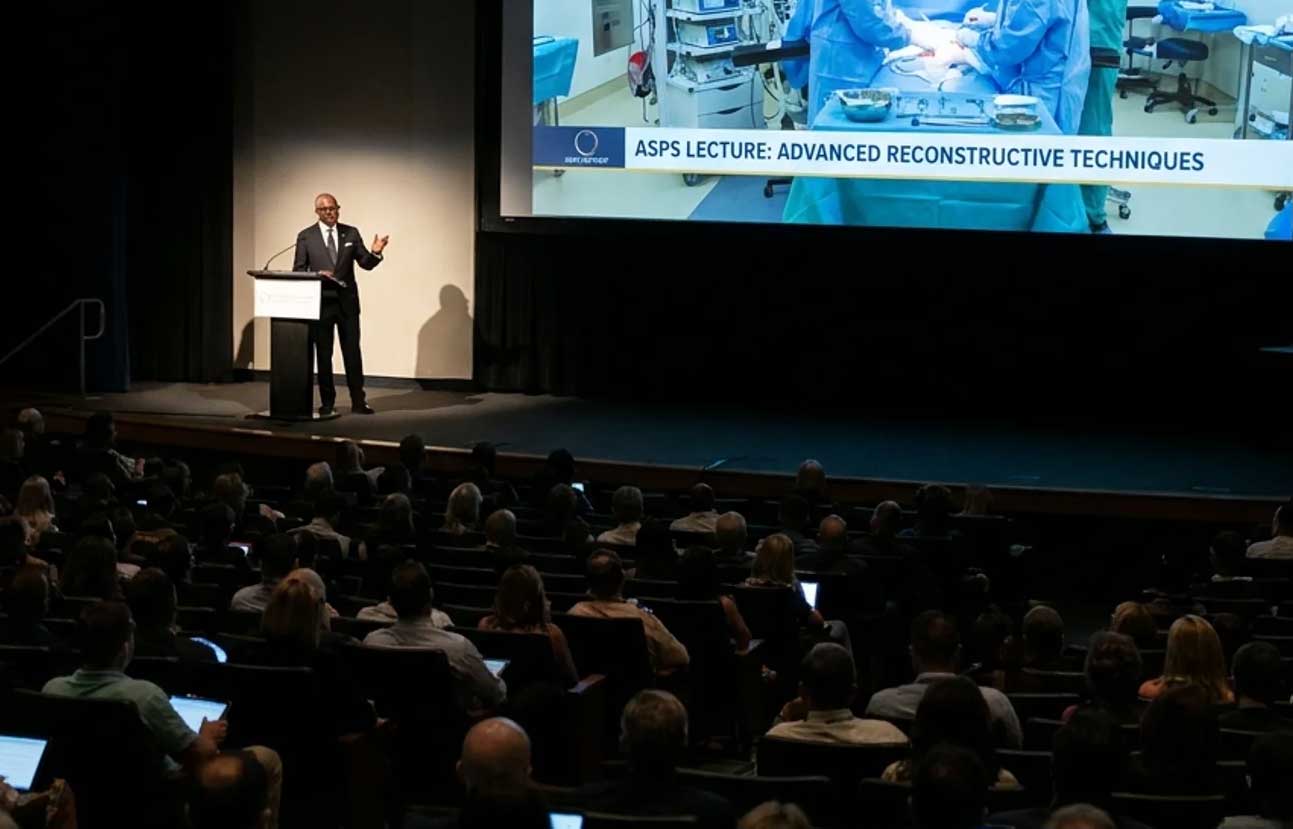 Distinguished surgeon at a lectern delivering a keynote, the national stage that defines the next ladder of the career